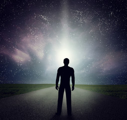 Man standing on the road looking at stars, sky, universe. Dream, adventure.
