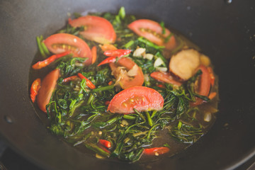 stir-frying kale with tomato, close up