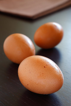 Fresh hen eggs on a brown wooden table