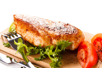 Roast chicken fillet and vegetables on white background