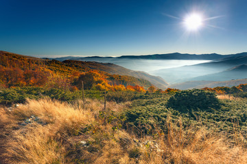 Fototapeta premium Autumn mountain scenery against rising sun