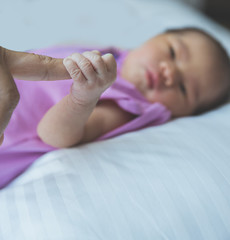 newborn baby curled up sleeping on a blanket, holding finger, cl