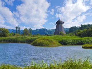 landscape with old ruinous windmill in wetlands and reed