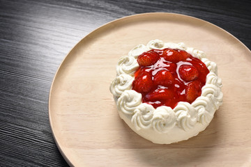 Fresh strawberry cake on wood plate