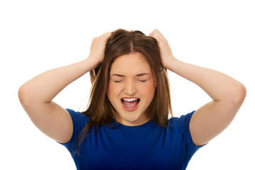 Frustrated young woman screaming.
