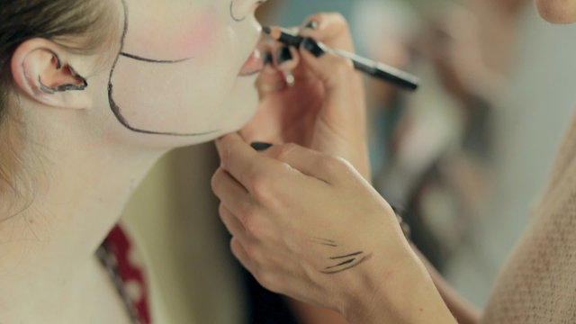 Make-up artist paints elements of the make-up on model, pop art