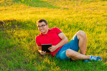 Naklejka na ściany i meble Man with tablet pc in park on a sunny day