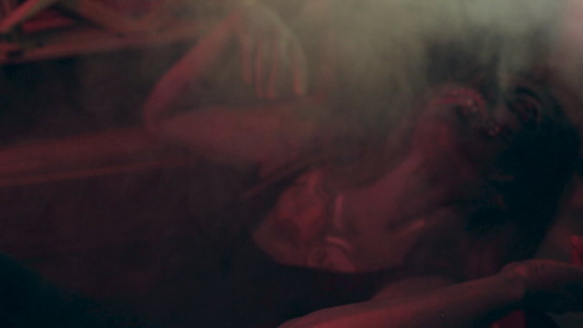 Terrible zombie crawls out of the grave in the smoke