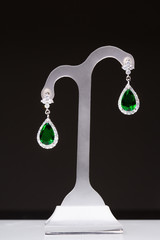 earrings with green stones on a stand