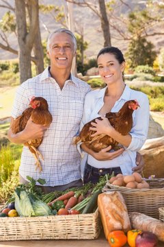  Happy farmers holding chicken and eggs