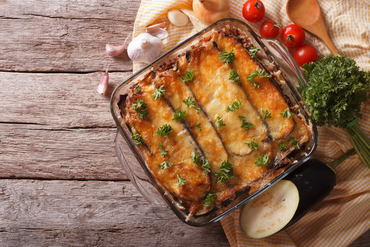Greek moussaka in baking dish with the ingredients. horizontal top view
