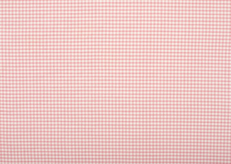 Close up on checkered tablecloth fabric. Pink with white tartan square pattern as background.