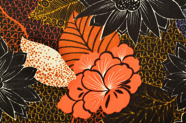 Orange floral pattern on fabric. Colorful abstract flower print as background.