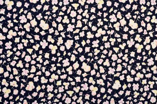 Small floral pattern on dark blue fabric. White and pink flowers print as background.