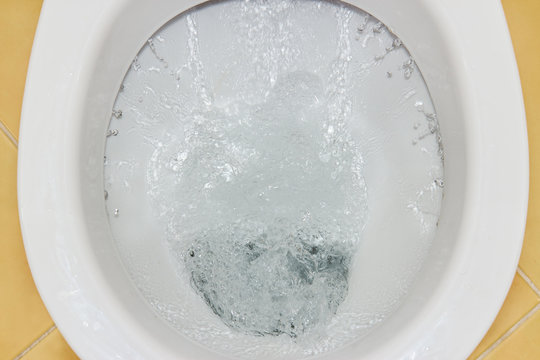 Closeup view of a flushing white toilet