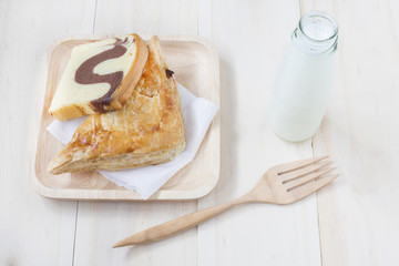 Fototapeta na wymiar Pie and chocolate marble cake and milk with wooden fork on woode