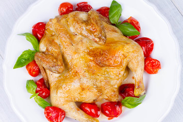 Whole roast chicken with tomatoes cherry, green basil and garlic