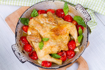 Whole roast chicken with tomatoes cherry, green basil and garlic