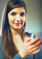 Smiling woman using smart phone.