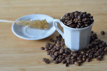 cup of coffee beans and a sugar stick