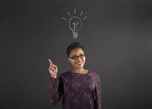 African American woman good idea with lightbulb on blackboard background