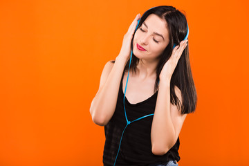 Young brunette woman listening to music with big headphones