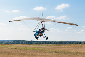 Obraz na płótnie Canvas The motorized hang glider over the ground