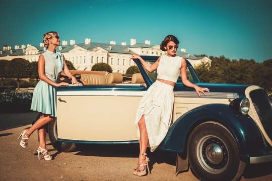 Two Stylish Ladies Near Classic Convertible