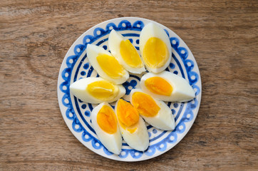 Sliced boiled eggs on a blue decorated plate