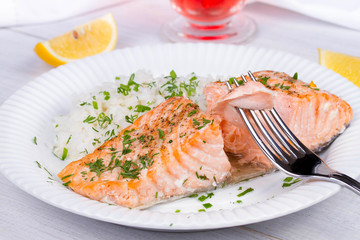 Steamed salmon with fresh herbs and lemon. Rice as a garnish