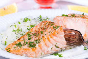 Steamed salmon with fresh herbs and lemon. Rice as a garnish