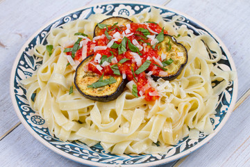 Tagliatelle pasta with grilled eggplant, spicy tomato sauce and parmesan cheese