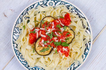 Tagliatelle pasta with grilled eggplant, spicy tomato sauce and parmesan cheese
