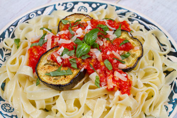 Tagliatelle pasta with grilled eggplant, spicy tomato sauce and parmesan cheese
