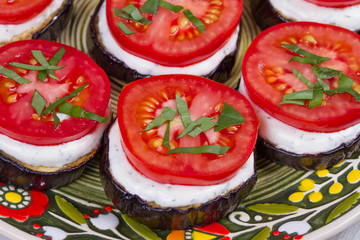 Grilled eggplant with spicy sour cream sauce, tomatoes and basil