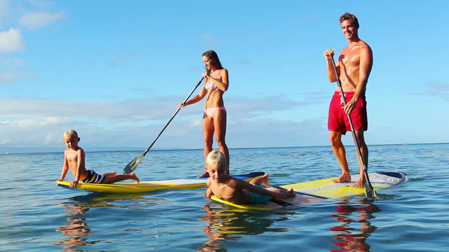 Family Stand Up Paddling on Sunny Blue Sky Morning. Summer Fun Family Vacation Healthy Lifestyle. Learning to Surf. SUP.
