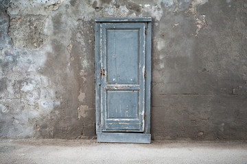 Old blue wooden door in dark concrete wall