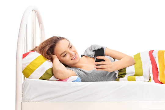 Woman lying in bed and looking at her phone