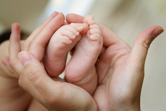 Child feet in mother's hands