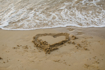The heart draw in the sand on the beach