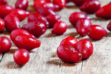 Cornel berries on old wooden background, selective focus