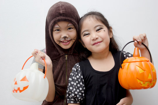 Portrait happy Asian girl with pumpkin bucket on halloween costume