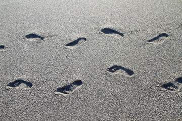 footprints on the beach of gray stones
