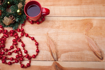 Christmas round garland near a red mug of hot drink