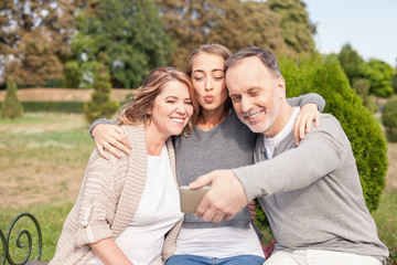 Obraz premium Pretty mature family is photographing themselves in park