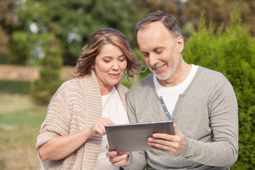 Pretty old husband and wife are using a tablet