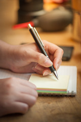 female hand writing on notepad