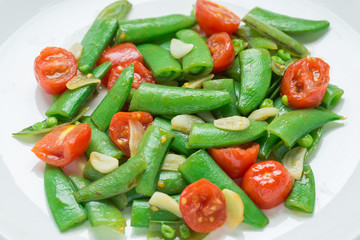 Close up, Stir fry sugar snap peas with tomato.