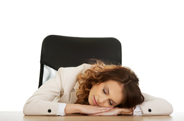 Obraz premium Businesswoman having a nap at her desk.