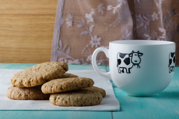 Oat cookies with big cup of milk on wood table
